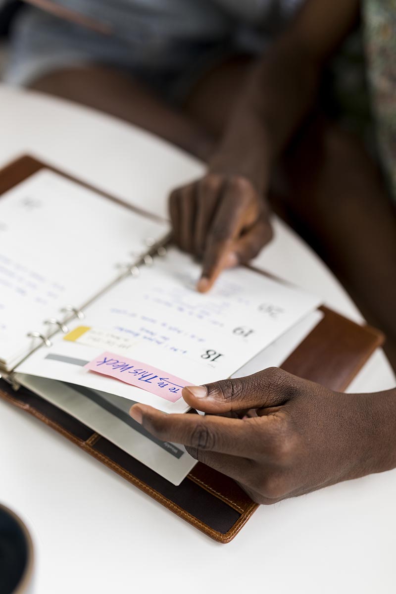 Black woman looking at her weekly planner