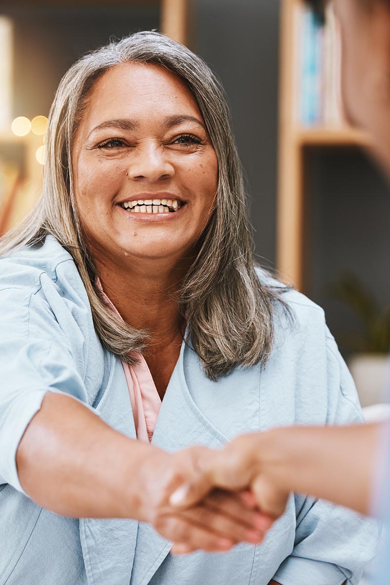 Handshake, healthcare and appointment with a senior woman shaking hands with a female nurse in a retirement home. Thank you, medical and meeting with a mature patient and medicine professional